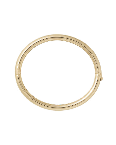 A gold-toned, tubular bangle with a hinge clasp.
