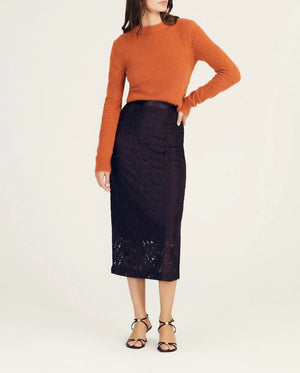 Model wears black lace midi skirt and orange sweater.