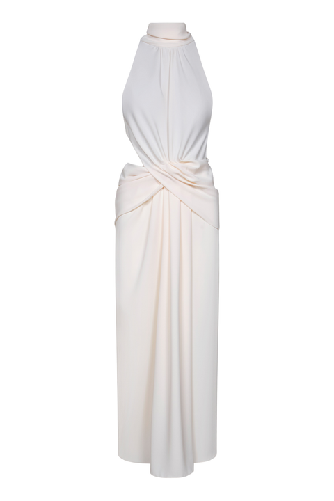An ankle-length cream halter dress with side draping and a cutout