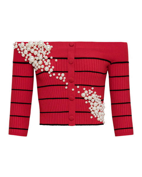 Red off the shoulder cardigan with black stripes and pearl embellishments on a white background