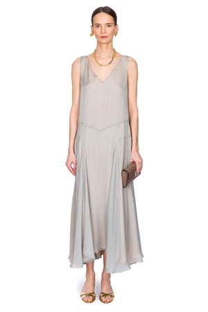 Woman wearing a light gray dress on a white background