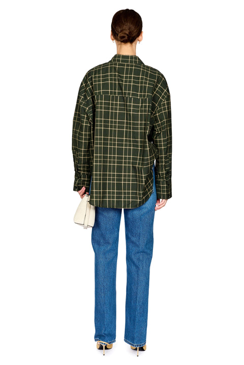 A model shown from the back wearing a dark green and black plaid button-down shirt, blue jeans, and black heels, holding a small white handbag against a plain white background.