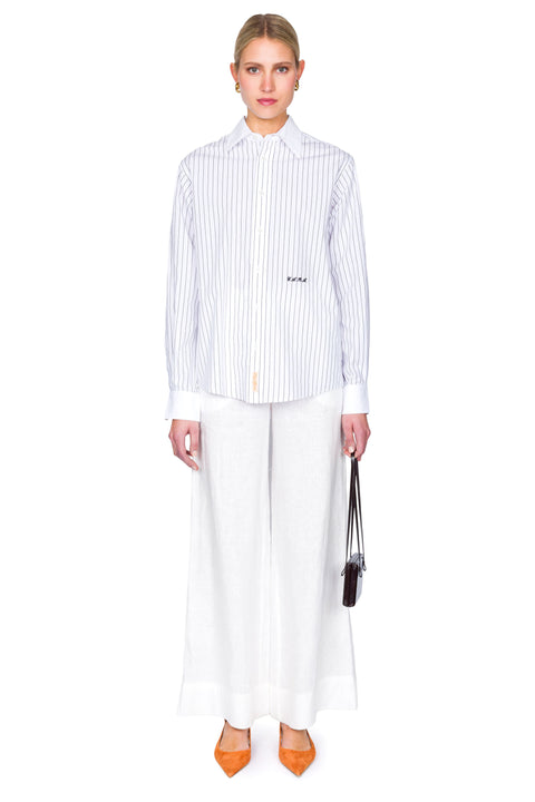 Woman wearing a striped shirt and white pants on a white background