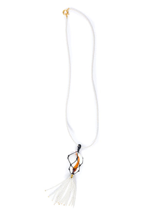 Pearl beaded necklace with a corded shell pendant and gold clasp, and tassel on a white background