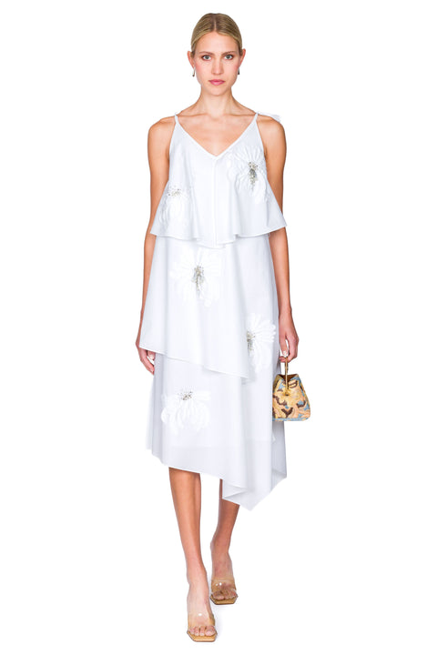 Woman wearing a white dress with a small multicolored handbag
