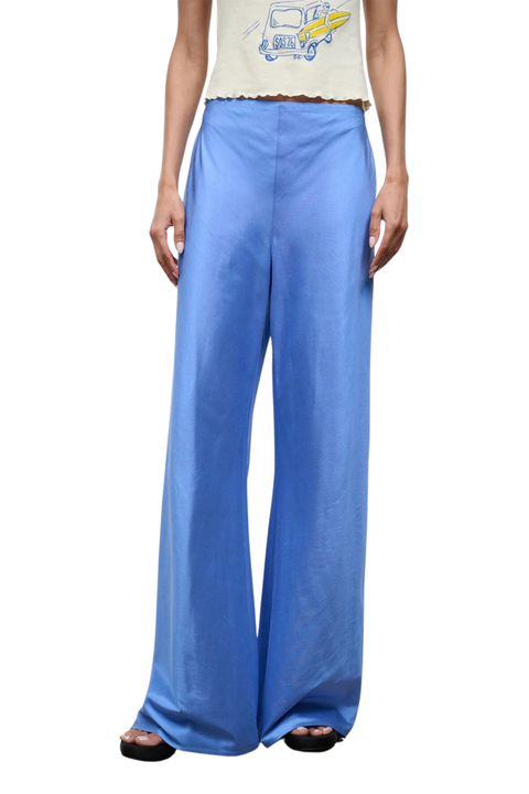 Close-up of a woman wearing bright blue silk trousers 