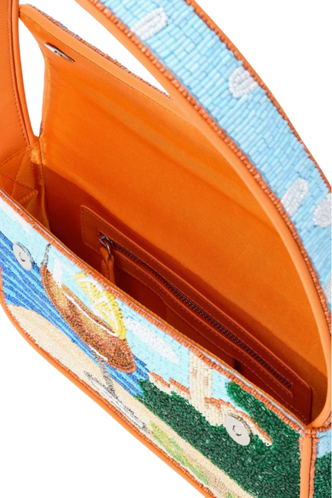 The orange interior of a beaded bag with a beach scene